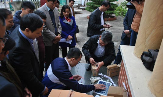 Cán bộ kỹ thuật của sở Công thương hướng dẫn bà con và cán bộ xã Đồng Nghê thao tác lắp đặt và sử dụng máy phát điện mặt trời Sola của công ty Vũ Phong trao tặng.