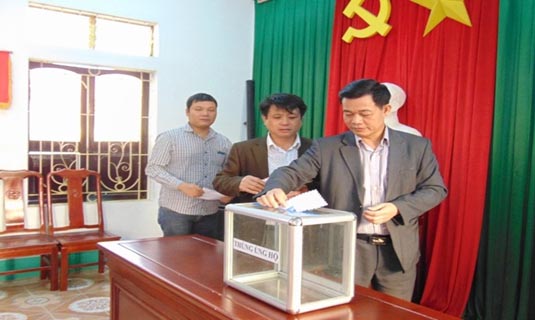 Cán bộ, viên chức BHXH huyện ủng hộ 1 ngày lương để mua và tặng thẻ BHYT cho người nghèo.